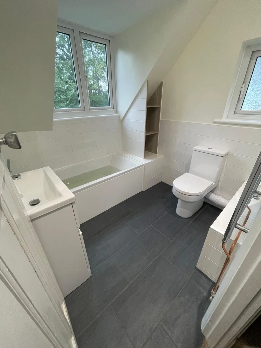 Bright loft family bathroom with metro tiles and slate-tiled floor — bathroom installation