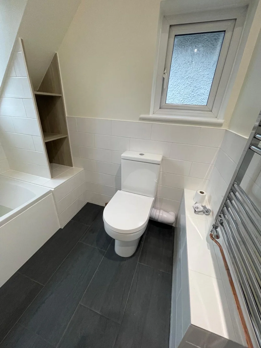 Loft bathroom with metro tiles, bespoke oak shelving and slate floor — bathroom installers in Reading