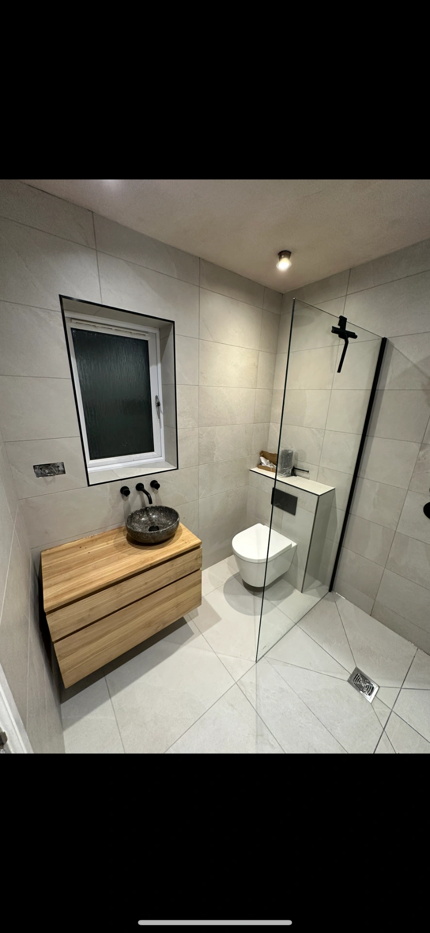 Wet room with oak floating vanity, stone vessel basin and black-framed walk-in shower — wet room installation