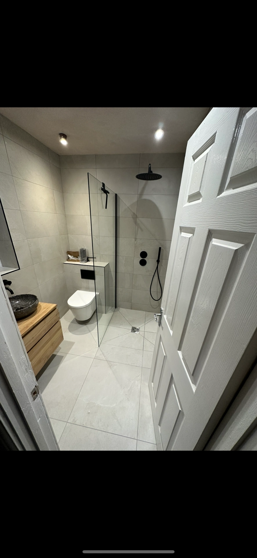 Modern wet room with oak vanity, stone vessel and matte black shower fittings — bathroom installation