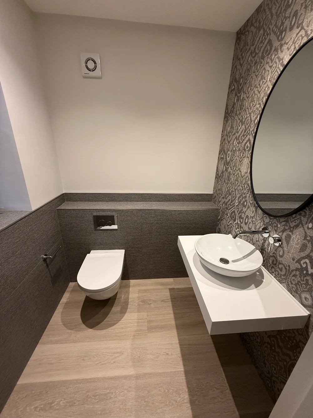 Bespoke cloakroom with patterned wallpaper, oak floor and floating vessel basin — Reading