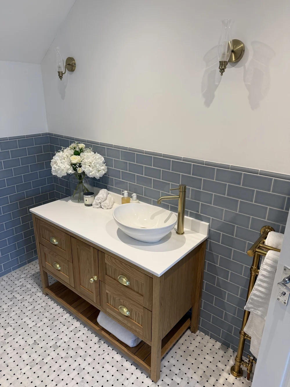 Oak vanity with vessel basin, brass tap and blue metro tiles — bathroom design