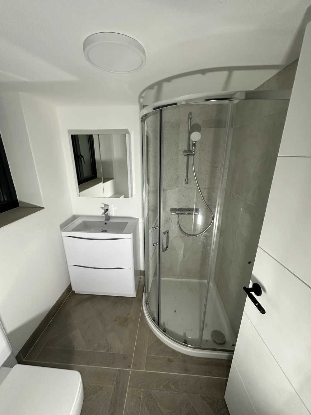 Loft shower room with quadrant enclosure, herringbone tile floor and floor-standing vanity — bathroom installation