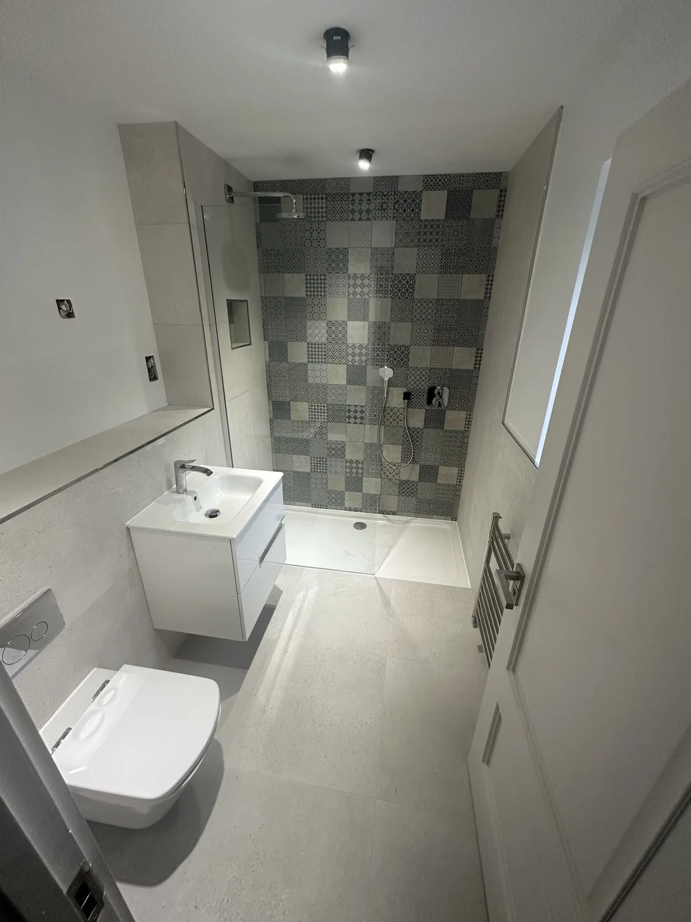 Compact shower room with patchwork feature wall and floating white vanity — bathroom installation in Reading