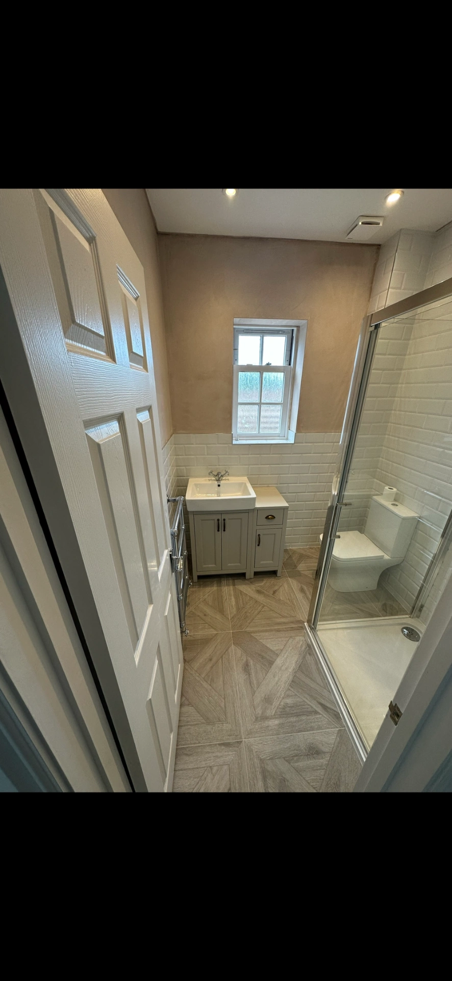 Compact shower room with shaker vanity, beveled metro tiles and chevron parquet floor — bathroom installation