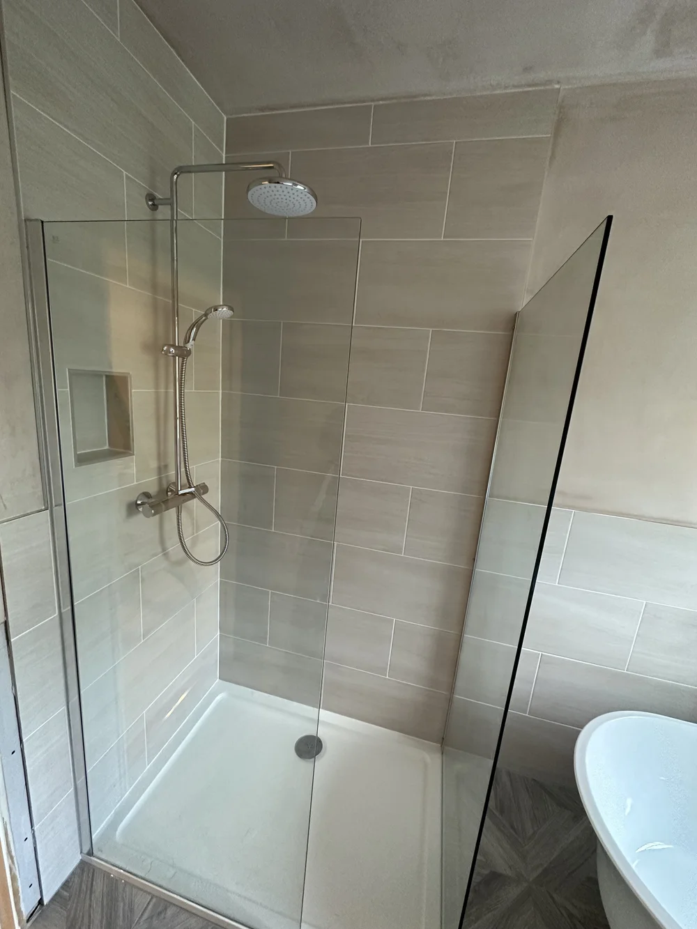 Walk-in shower with cream metro tiles, brushed nickel rainfall column and glass screen — bathroom installation